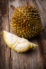 Fresh durian on wooden background. Monthong breed. With dark vignette.