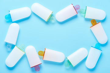 Ice cream molds lying like a frame on cyan surface