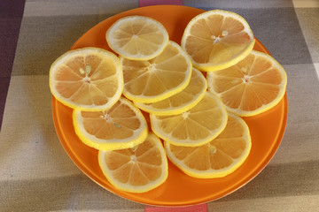 Slices of fresh lemon on an orange dish