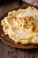 Plate of creamy hummus on wooden table.Ramadan food. Selective focus. Toned image