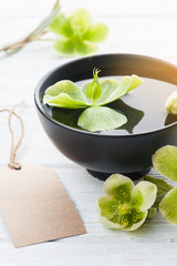 Green flowers, bowl and lit candle
