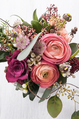 Bouquet of flowers in tin mug on light background