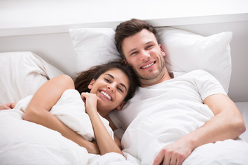 Smiling Couple On Bed