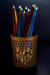 Colored pencils are visible through a wicker glass