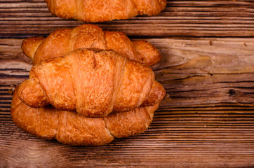Fresh croissants on wooden table. Top view
