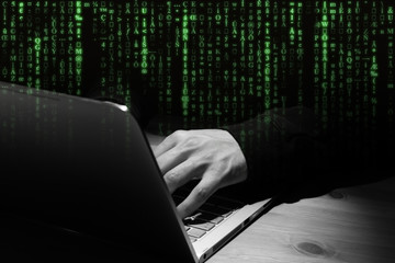 Mann beim Hacken am Notebook.