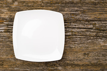 The white square plate on a wooden background 