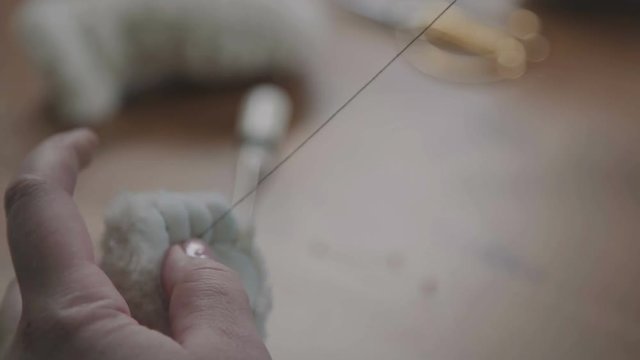 Teddy bear: the process of creation. Sewing a soft toy: a woman doing a teddy bear. The concept of exclusive work. Craft production. Details and elements of a soft plush toy