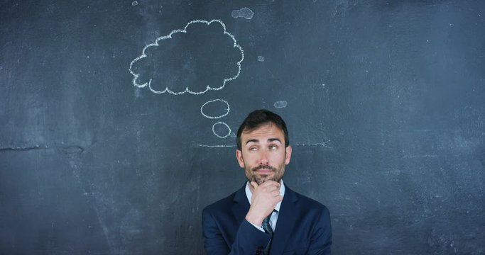 Portrait of a beautiful business man, a marketing teacher, thinking about new ideas and strategies, on a black background. Concept: career growth, growth chart, successful man, marketing, ideas.