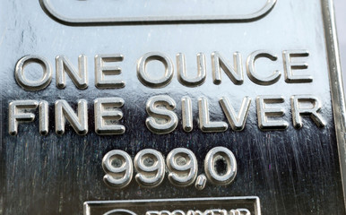 The surface of minted silver bar weighing one troy ounce. The texture of the surface of the silver ingot. Selective focus.