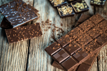 Chocolate bar pieces with cocoa powder.  Background with chocolate. Slices of chocolate,  Copyspace