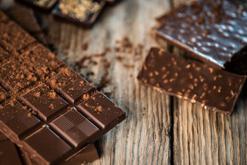 Chocolate bar pieces with cocoa powder.  Background with chocolate. Slices of chocolate,  Copyspace