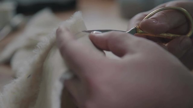 The process of creating a plush toy. A hand-made teddy bear. Teddy bear in the vintage style is an old-fashioned toy of the 20th century. Master makes a detail - cuts the fur to make a collectible toy