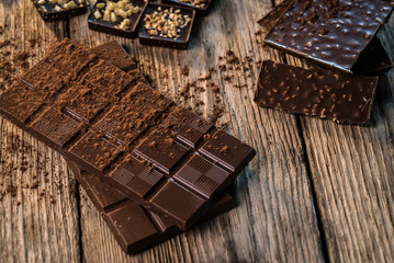 Chocolate bar pieces with cocoa powder.  Background with chocolate. Slices of chocolate,  Copyspace