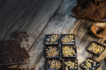 Chocolate bar pieces with cocoa powder.  Background with chocolate. Slices of chocolate,  Copyspace