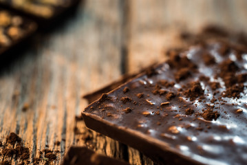 Chocolate bar pieces with cocoa powder.  Background with chocolate. Slices of chocolate,  Copyspace