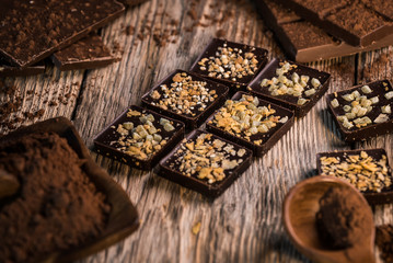 Chocolate bar pieces with cocoa powder.  Background with chocolate. Slices of chocolate,  Copyspace