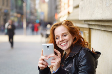 lachende frau macht ein foto mit ihrem handy