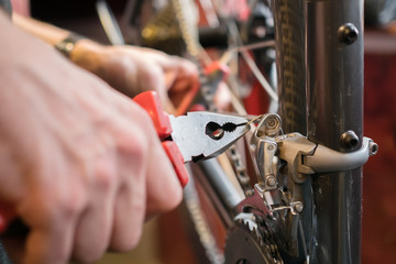 Man with pliers repairing bicycle