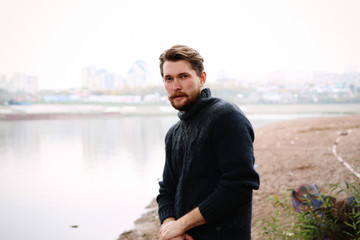 Fototapeta na wymiar Handsome bearded man on the background of the river
