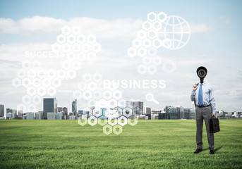 Camera headed man standing on green grass against modern citysca