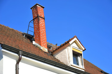 Schornstein aus Ziegelmauerwerk auf einem Ziegeldach