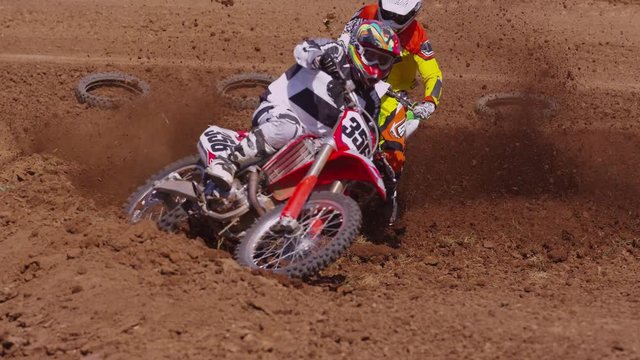 Motocross racers going around corner 