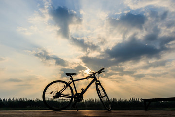 silhouette of bicycle near lake  and Sunset on beautiful sky