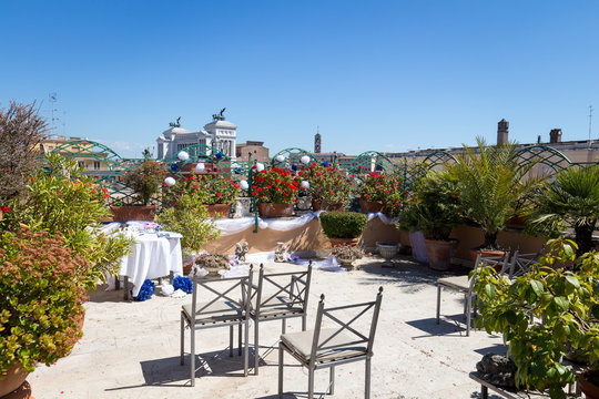 Wedding decor, table setting, floral arrangements on the rooftop terrace with Rome view in the background, Italy
