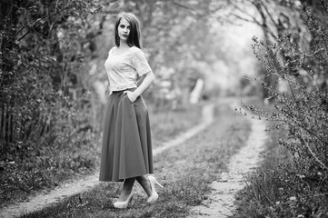 Portrait of beautiful girl with red lips at spring blossom garden, wear on red dress and white blouse.