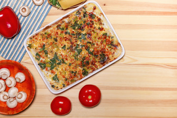 Chicken vegetable cheese pie, pizza on the light wooden background
