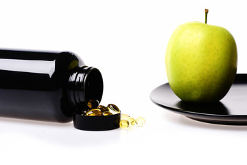 green apple fruit and fish oil in black plastic bottle