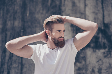 Stylish young red bearded guy in  casual clothes outdoors. He looks serious, fixing his perfect hairdo © deagreez