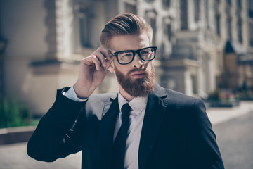 Nerdy hot bearded guy in a formal wear and glasses outside. He is so harsh and mature, stylish and fashionable