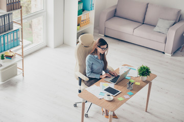 Top view photo of elegant lady lawyer sitting in her bright office and browsing info in laptop. She...