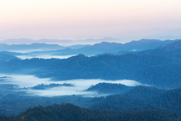 Fototapeta na wymiar high angle view of layer tropical mountains with white fog in Thailand.