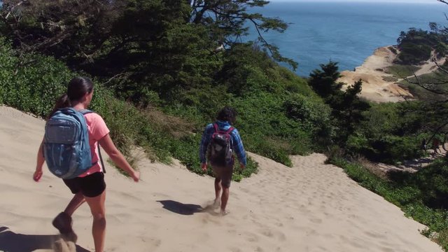 Couple hiking on sand dunes at beach