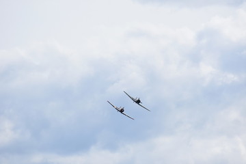 Airplane aerobatics, two airplanes flying together on an airshow.