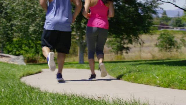 Couple running at park, closeup of feet