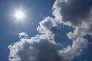 Naklejka na ściany i meble 眩しい太陽と青空と雲「空想・雲のモンスター（中央に両手を前に出して、太陽を見つめる子供のモンスターと顔を寄せる親モンスターの姿など」（突き抜ける、紫外線、見守る、愛情、希望、暑い、融けるなどのイメージ、右や下の雲などにタイトルスペース（案・「暑さ全開！」