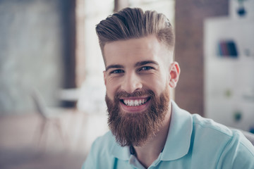 Close up portrait of stylish handsome man with beaming smile. He has great hairdo