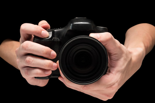 Male hand holding a digital camera on a black background.