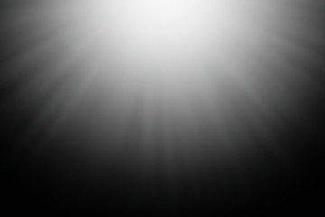 Blurred abstract light rays on a black background.