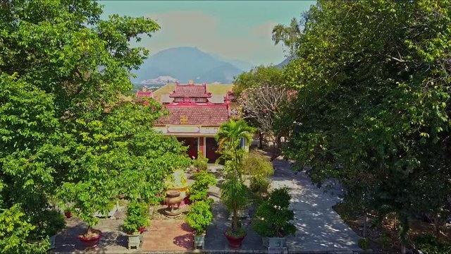 aerial view of green garden with small Buddha statue near nice houses against spectacular mountain and blue sky