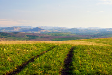 Fototapeta premium Landscape with country road in the spring foothills of Altai mountains Siberia Russia