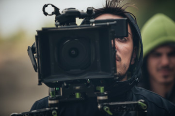 Behind the scene. Cameraman shooting film scene with his camera
