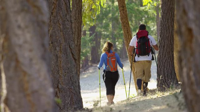 Couple hiking outdoors through trees