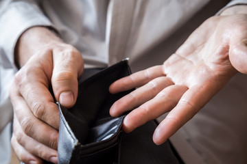Obraz na płótnie Canvas Man's hand holding an empty black money wallet. 