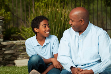 African American father and son talking and laughing.