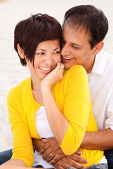 Fototapeta premium Happy couple laughing and talking at the beach.